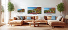 A cozy living room with a large sectional sofa, a coffee table, and three framed landscape photographs of a winding road through a forest.