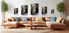 a modern living room with a large sectional sofa, a coffee table, and several potted plants. The sofa is positioned in front of a wall with four framed black and white photographs of abstract designs, each with a different size and resolution.