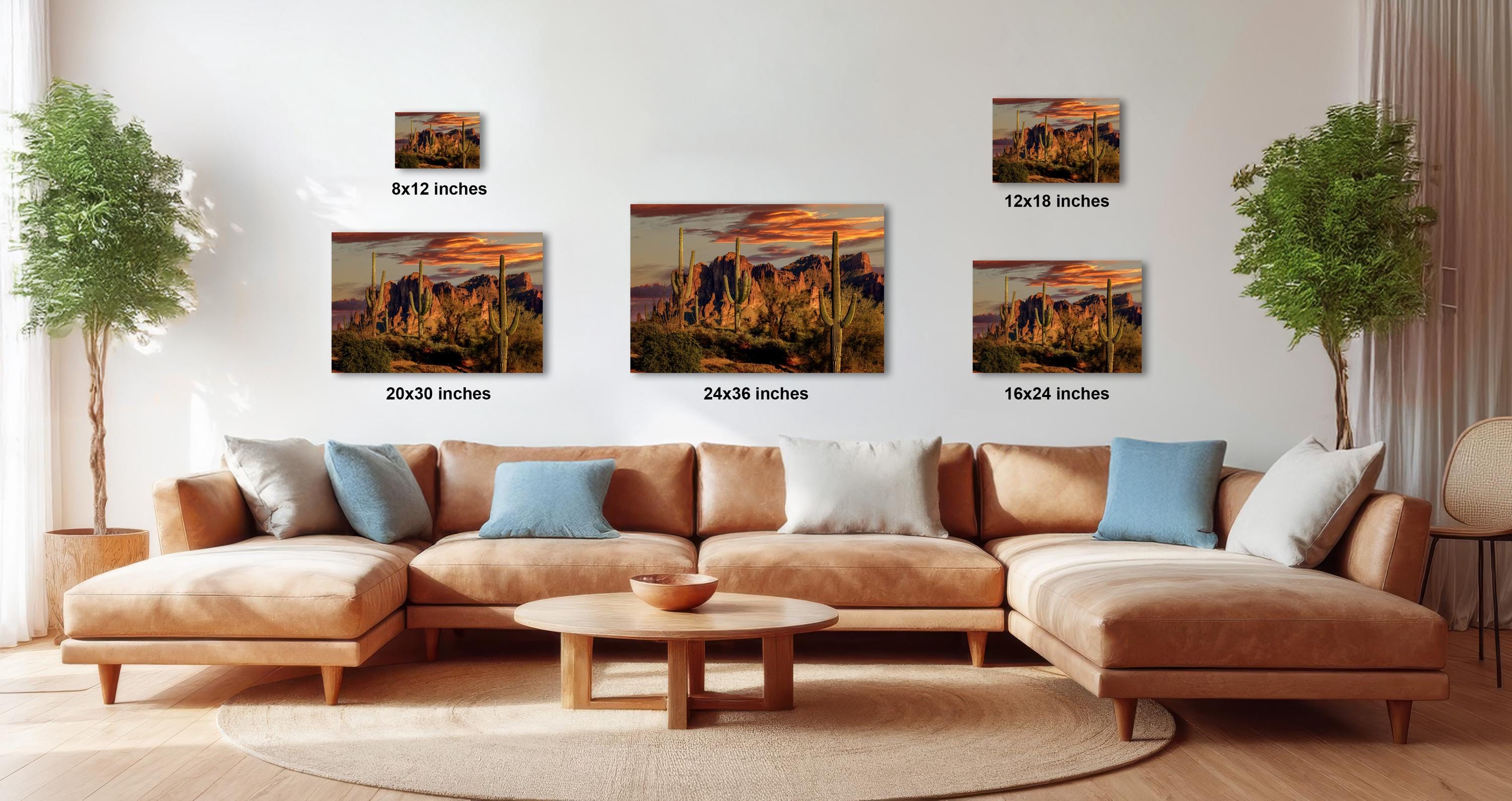 a living room with a large sectional sofa, a coffee table, and several framed landscape photographs displayed on the wall.