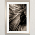 The image is a black and white photograph of a natural rock formation, likely a canyon or rock wall, with a textured and layered appearance.