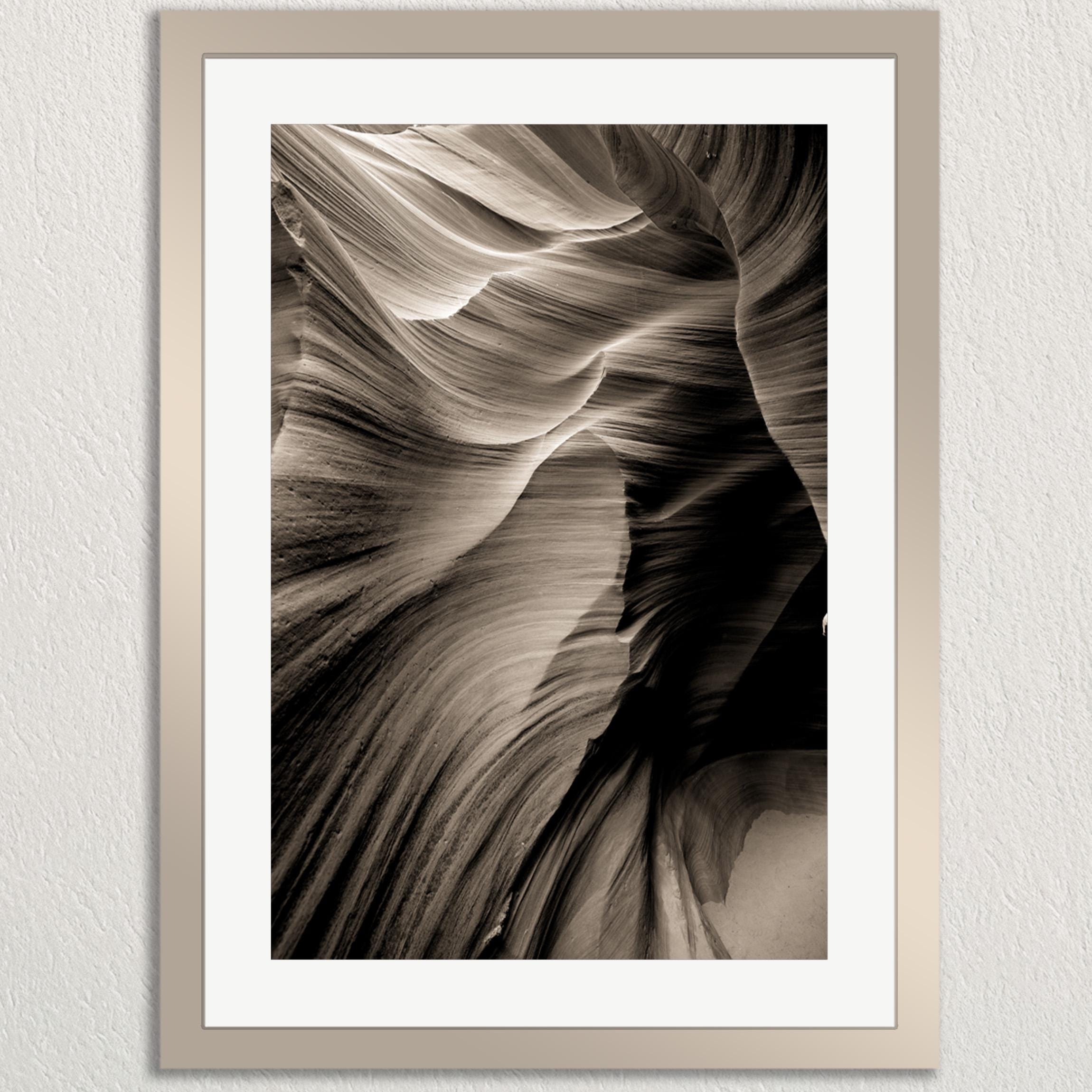 The image is a black and white photograph of a natural rock formation, likely a canyon or rock wall, with a textured and layered appearance.