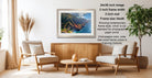 a living room with a wooden coffee table, two white armchairs, and a framed landscape photograph hanging on the wall.