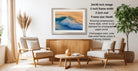 a modern living room with a wooden coffee table, two white armchairs, and a framed photograph of a crashing wave hanging on the wall.