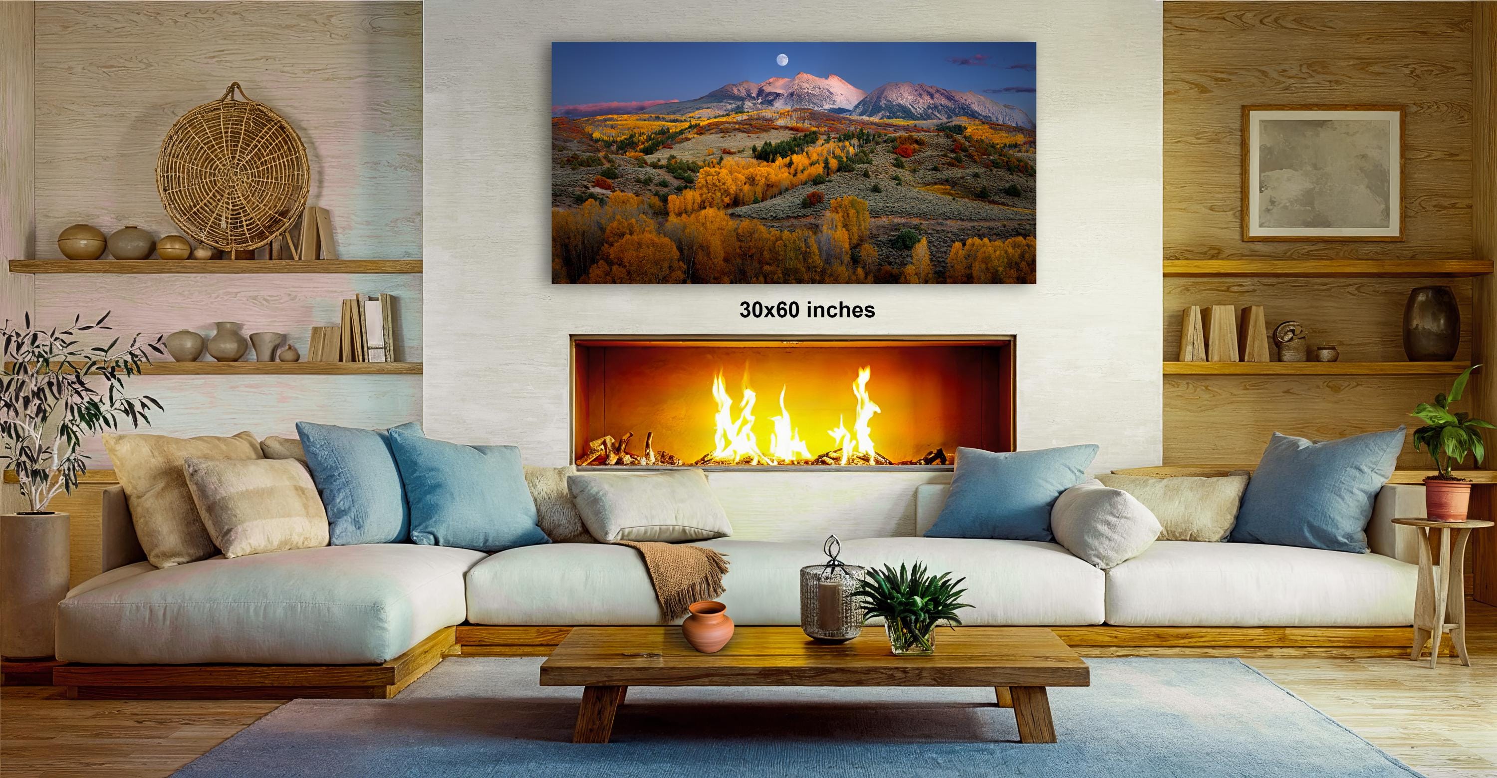 a cozy living room with a fireplace, a large framed landscape painting on the wall, and a wooden coffee table in front of the fireplace.