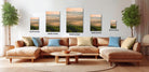a large, brown sectional sofa with multiple pillows, a coffee table, and a potted plant in a living room setting. The sofa is positioned in front of a wall with four framed landscape paintings of varying sizes, each depicting a mountain scene. The paintings are arranged in a row, with the largest one being 24 inches wide and the smallest one being 16 inches wide.