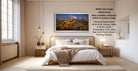 The image is a modern bedroom with a large bed, wooden furniture, and a framed landscape photograph hanging on the wall.