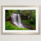 A framed photograph of a waterfall cascading down a rocky cliff surrounded by lush greenery.