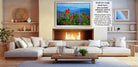 a cozy living room with a fireplace, white sofas, and a coffee table. The room has a warm and inviting atmosphere, with a large framed picture of a field of flowers hanging on the wall.