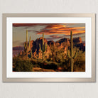 a desert landscape with towering red rock formations silhouetted against a vibrant sunset sky.