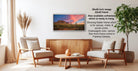 a living room with a wooden coffee table, two white armchairs, and a potted plant. A framed landscape photograph is hanging on the wall, and there is text providing information about the frame options.