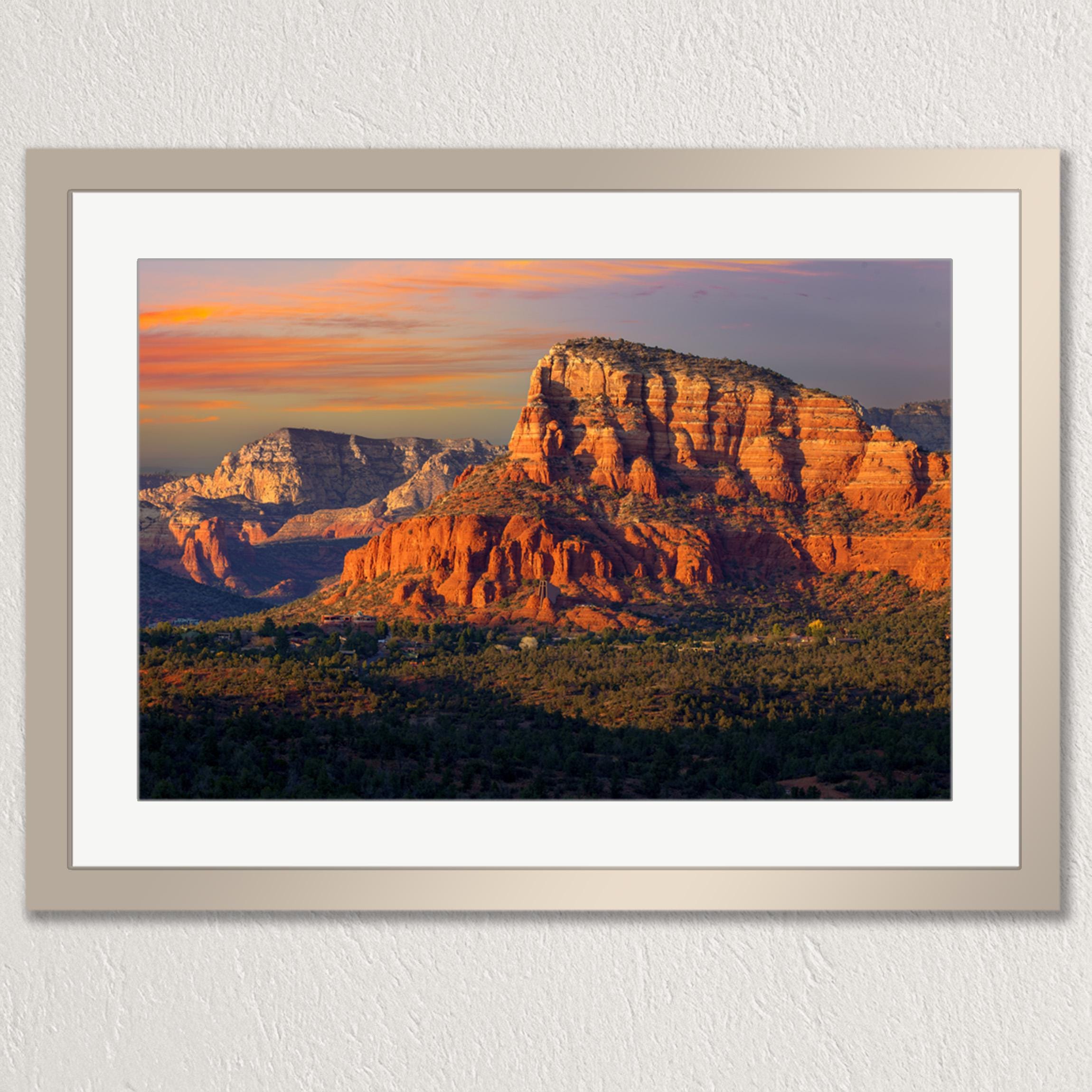 a breathtaking view of a mountainous landscape at sunset, with the sun setting behind the mountains and casting a warm, golden glow over the scene.