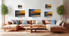 The image is a modern living room with a large sectional sofa, a coffee table, and several potted plants. The walls are decorated with three framed landscape photographs, each varying in size and depicting different scenes. The photographs are arranged in a grid-like pattern, with the largest one at the top and the smallest at the bottom.