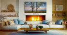 a cozy living room with a fireplace, a large painting of trees on the wall, and a comfortable couch and coffee table arranged around it.