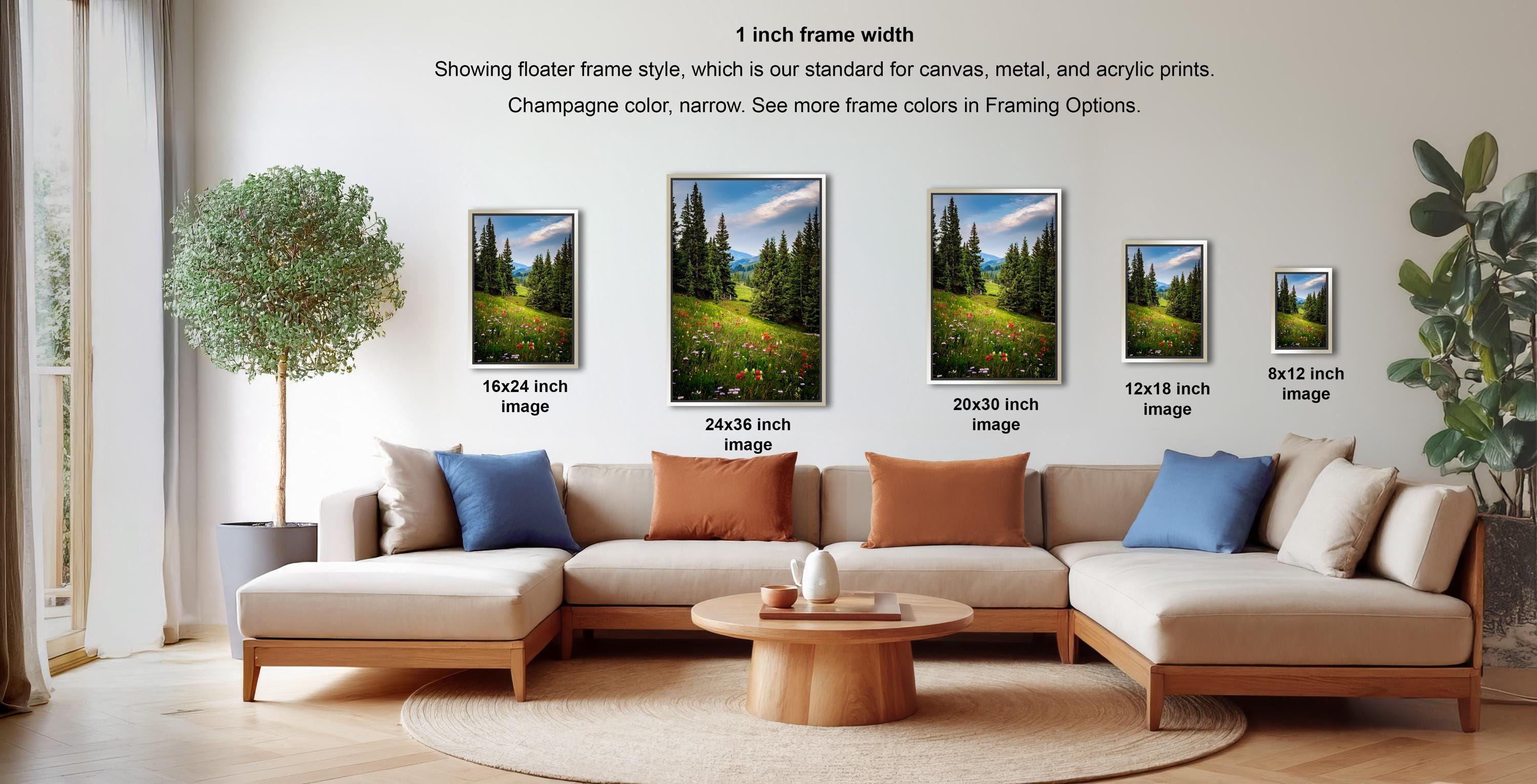 a living room with a large sectional sofa, a coffee table, and several framed landscape paintings displayed on the wall.