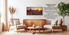 a living room with a wooden coffee table, two white armchairs, and a framed landscape painting hanging on the wall.
