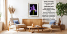 a living room with a framed photograph of a purple iris on the wall, a wooden coffee table in the center, and two white armchairs facing each other.