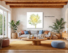 a cozy living room with a large white flower on the wall, a gray sofa, a wooden coffee table, and several potted plants.