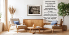 a living room with a wooden coffee table, two armchairs, and a framed black and white photograph hanging on the wall.