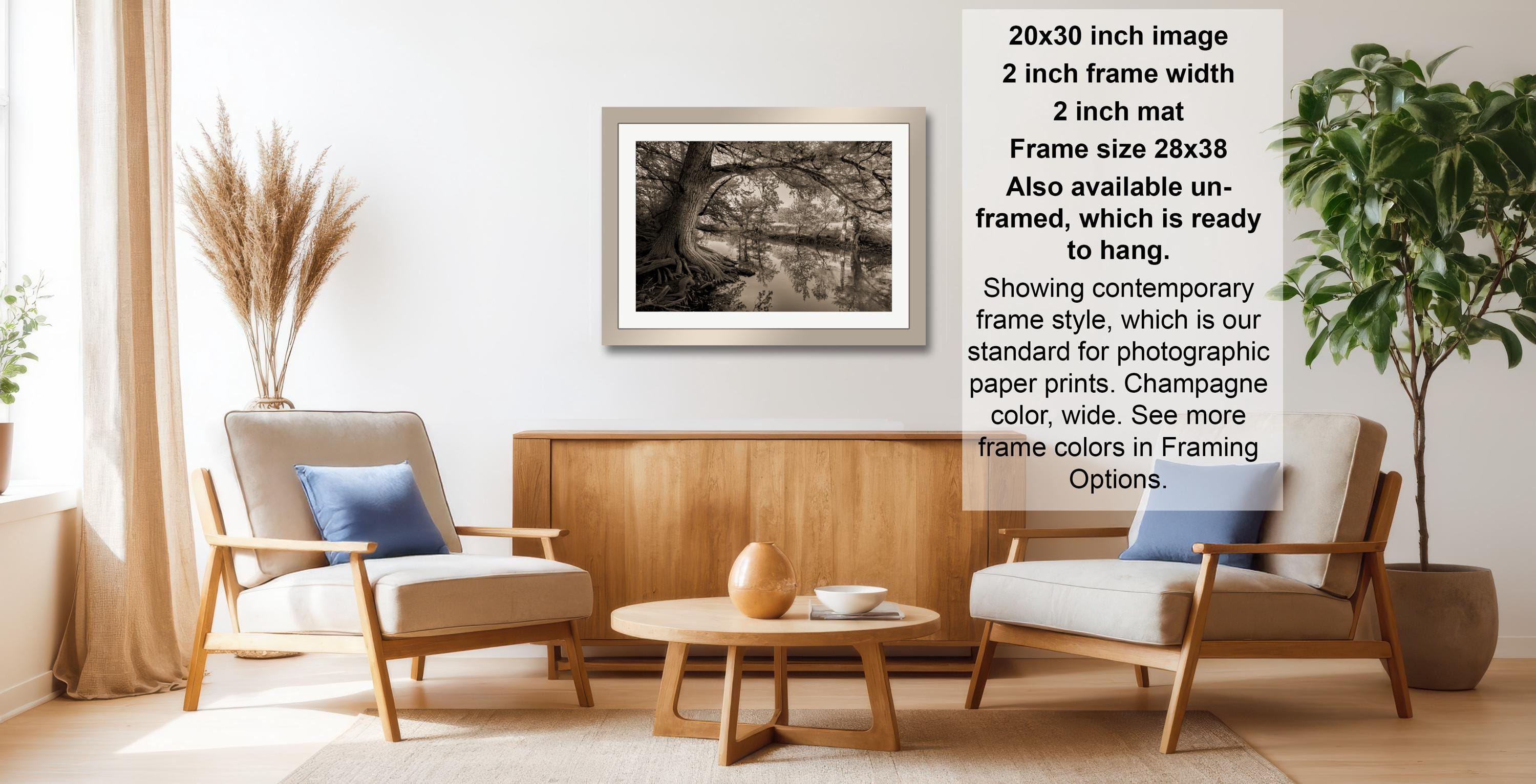 a living room with a wooden coffee table, two armchairs, and a framed black and white photograph hanging on the wall.