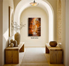 a hallway with a wooden bench on the left side, a wooden table on the right side, and a large painting hanging on the wall. The painting is of a woman with flowing hair and a flowing dress, and it is framed in a wooden frame. The hallway has a high archway and a chandelier hanging from the ceiling, creating a warm and inviting atmosphere.