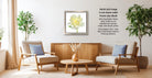 a cozy living room with two beige armchairs, a wooden coffee table, and a framed picture of a yellow flower on the wall.