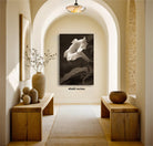 a hallway with a large black and white photograph of a flower hanging on the wall. The photograph is framed and measures 40.60 inches in size. The hallway features wooden benches and tables, and there are decorative elements such as vases and a bowl on display.