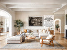 The image is a spacious living room with a large sectional sofa, a coffee table, and various decorative elements such as potted plants and vases.