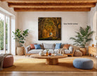 a cozy living room with a large window overlooking a tree-lined path. The room is furnished with a gray sofa, a wooden coffee table, and several potted plants. A large framed painting of a tree-lined path hangs on the wall, adding a natural element to the space.