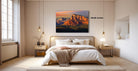a serene bedroom with a large bed, wooden nightstands, and a painting of a mountain landscape hanging on the wall.