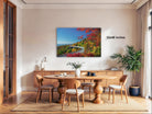 a dining room with a large wooden table surrounded by chairs, a vase of flowers, and a painting of a scenic mountain road.