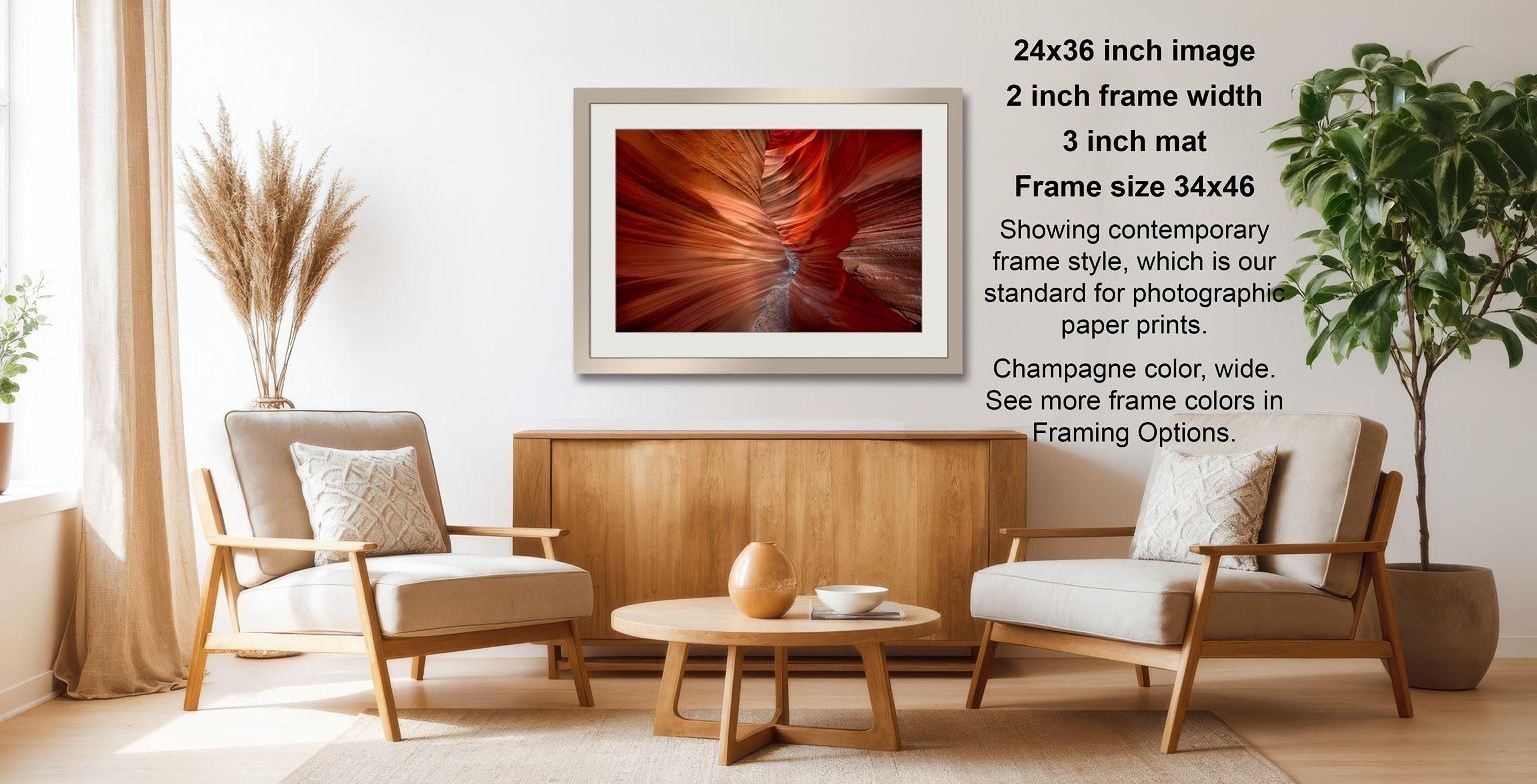 The image is a modern living room with a wooden coffee table, two white armchairs, and a framed photograph of a red abstract pattern hanging on the wall.
