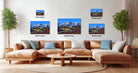 a living room with a large sectional sofa, a coffee table, and several framed landscape paintings displayed on the wall.