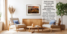a living room with a framed landscape photograph hanging on the wall, a wooden coffee table in the center, and two chairs facing each other.