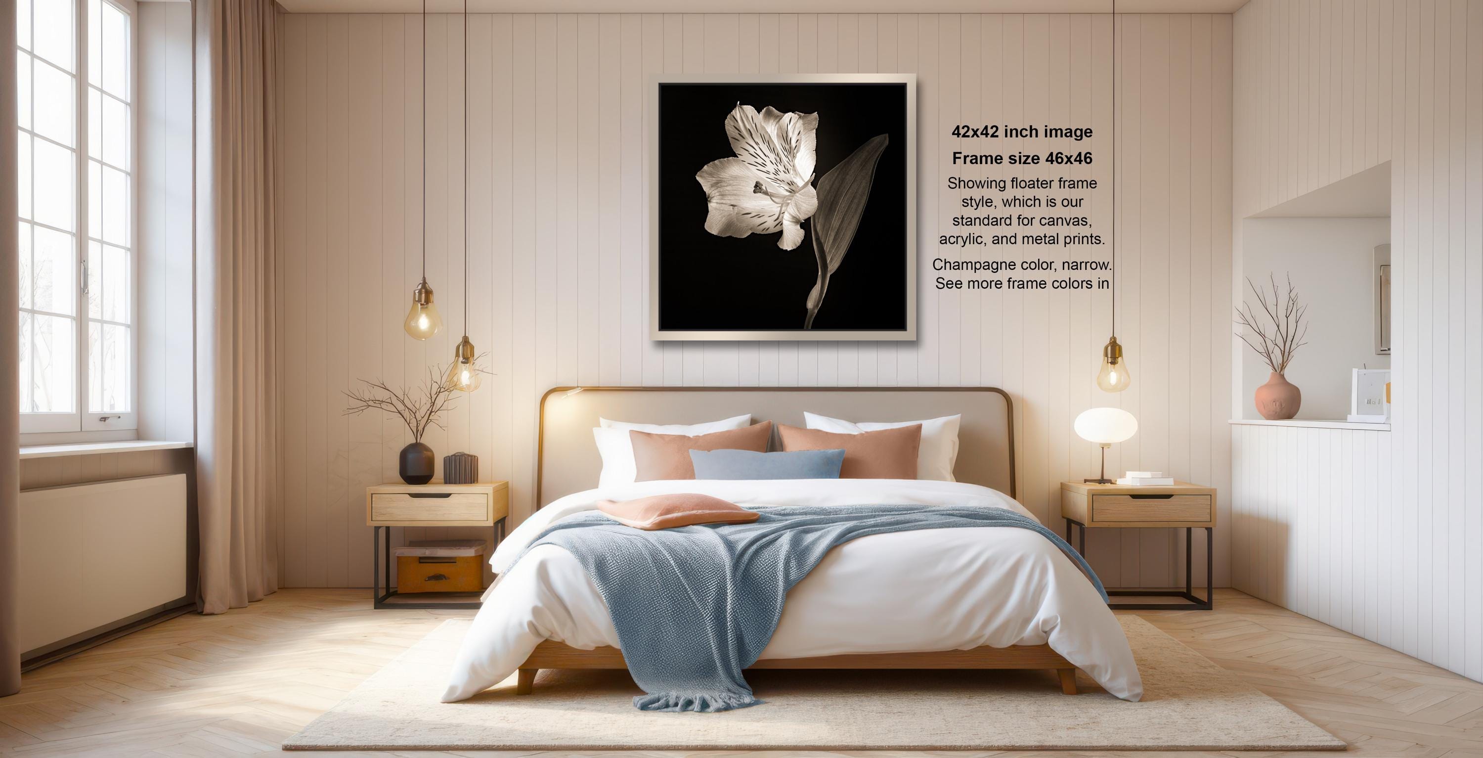 a serene and modern bedroom with a large bed, wooden furniture, and a large framed artwork featuring a white flower on the wall.