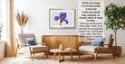 a living room with a framed purple flower on the wall, a wooden coffee table, two white armchairs, and a potted plant. The room has a modern and minimalist design, with a neutral color palette and clean lines.