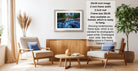a living room with a framed photograph of a river and waterfall hanging on the wall. The room has two armchairs, a coffee table, and a potted plant. The photograph is framed in a modern style, and the frame size is 28.38 inches wide. The text indicates that the frame is available in both framed and unframed versions, and it is ready to hang.