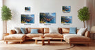 a large, brown sectional sofa with multiple pillows, a wooden coffee table, and a potted plant in the background. The sofa is positioned in front of a wall with three framed photographs of mountainous landscapes, each with a different size and resolution.