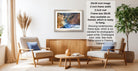 a living room with a wooden coffee table, two white armchairs, and a framed landscape photograph hanging on the wall.