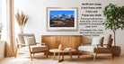 a living room with a wooden coffee table, two white chairs, and a framed landscape photograph hanging on the wall.