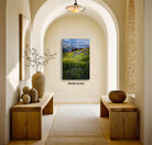 a serene and inviting hallway with a large painting of a lush green field and mountains in the background, creating a sense of tranquility and natural beauty.