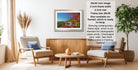 a living room with a framed landscape photograph hanging on the wall, a wooden coffee table in the center, and two chairs facing each other.