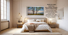 The image is a modern bedroom with a large bed, wooden furniture, and a painting of trees on the wall. The painting is framed in a frame that matches the color scheme of the room. The room has a minimalist and clean design, with a large window providing natural light.