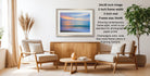 a living room with a framed landscape painting hanging on the wall, two white armchairs, a wooden coffee table, and a potted plant.
