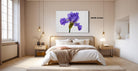 a bedroom with a large bed, a nightstand, and a painting of a purple iris on the wall.