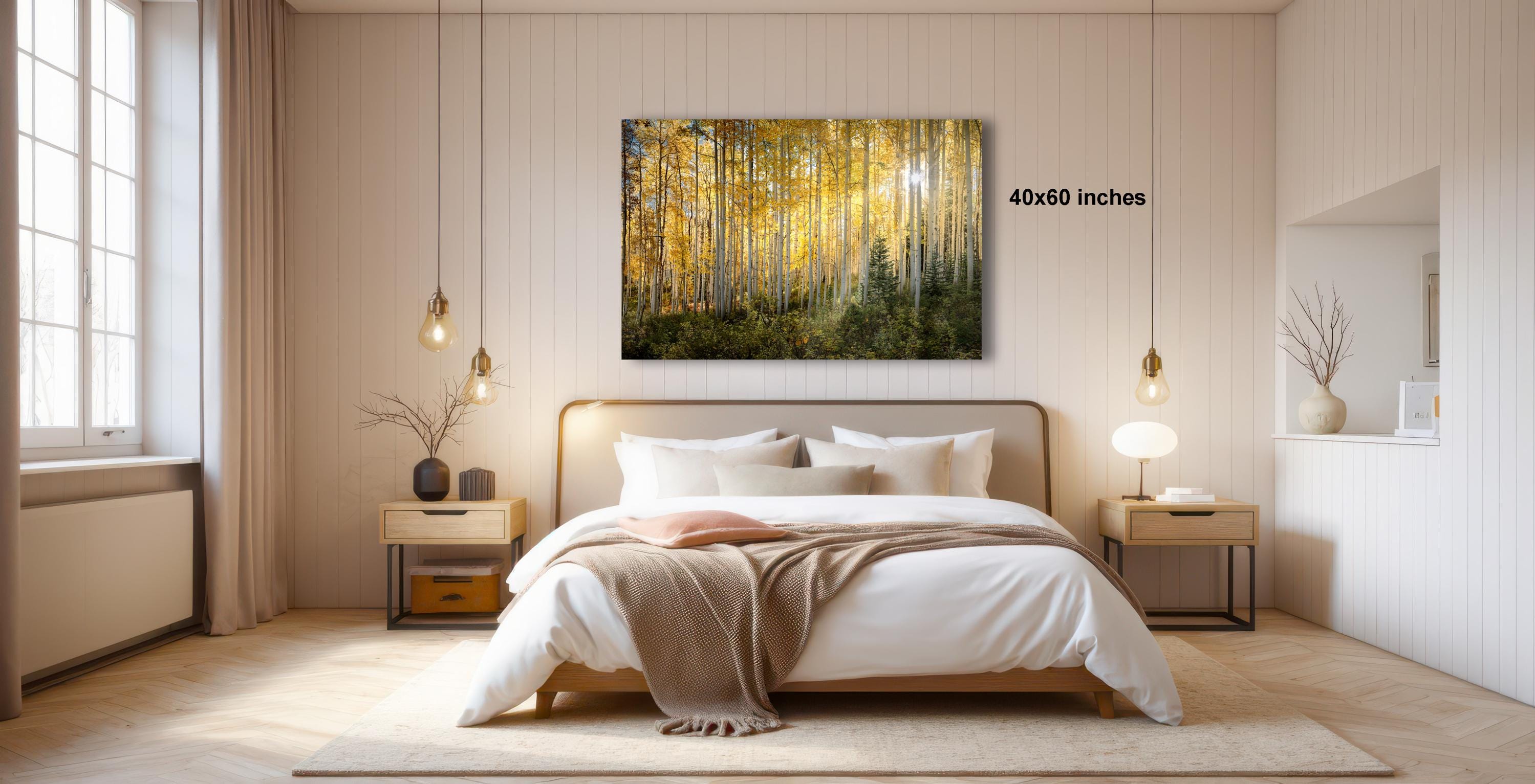 a serene bedroom with a large bed, wooden furniture, and a painting of a forest scene hanging on the wall.