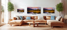 The image is a modern living room with a large sectional sofa, a coffee table, and three framed landscape paintings hanging on the wall.