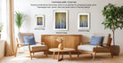 a modern living room with a wooden coffee table, two armchairs, and a potted plant. There are three framed artworks displayed on the wall, each with a different frame style and size.