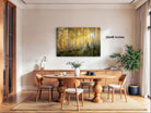 a dining room with a large wooden table surrounded by chairs, a potted plant, and a painting of a forest scene hanging on the wall.