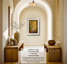 The image is a framed photograph of a forest path, hanging on a wall in a room with wooden furniture and decorative items.