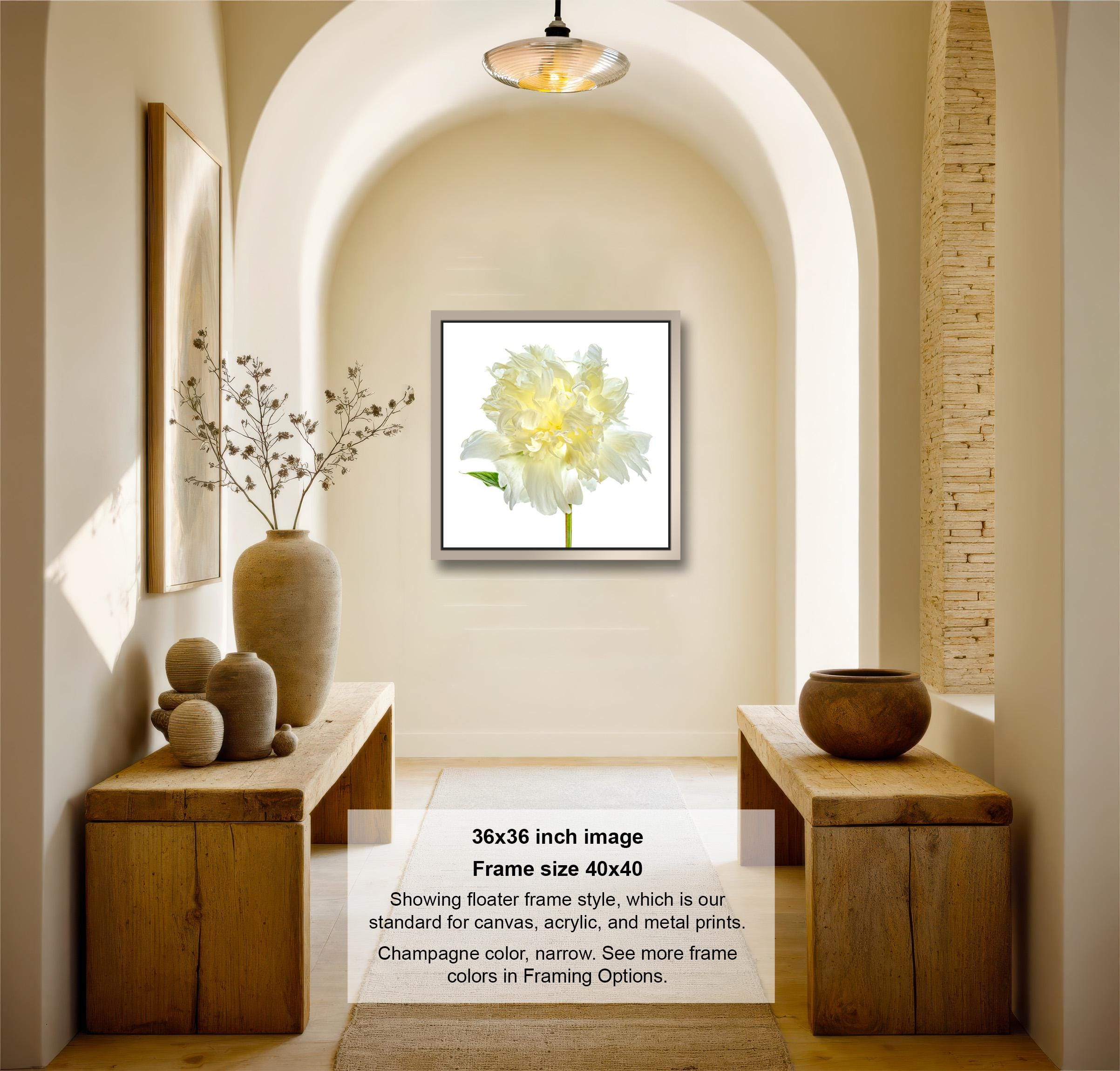 A modern and minimalist interior design featuring a large framed image of a yellow flower on the wall, flanked by two wooden tables with decorative items such as vases and a bowl.